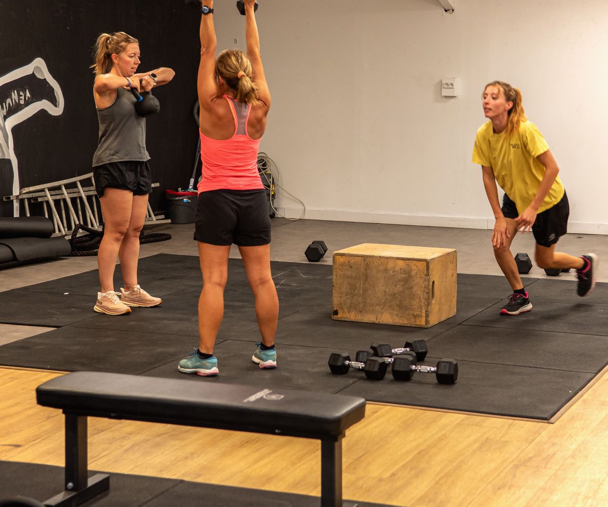 Cours de cross-training : développé aux haltères, kettlebell et fentes, près de la box de saut