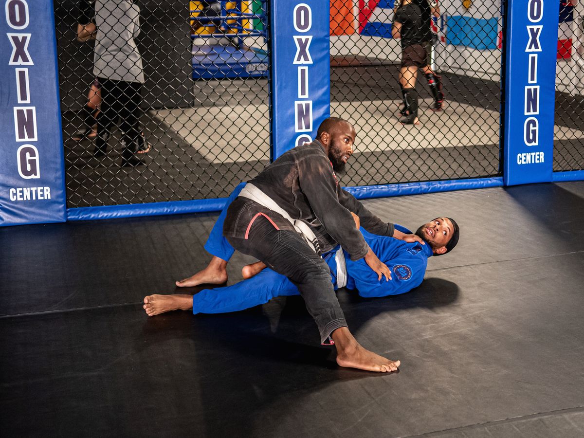 Grappling au sol devant la cage MMA, pendant un cours
