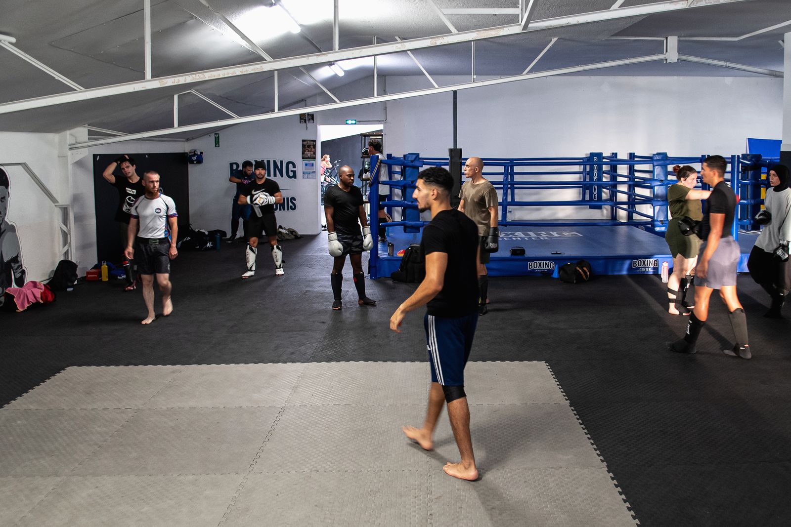 La grande salle du Boxing Center Toulouse États-Unis : ring, tatamis et un cours en pleine séance