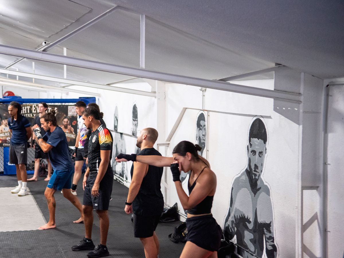 Cours de boxe anglaise : une ligne de jabs devant la fresque d’un boxeur