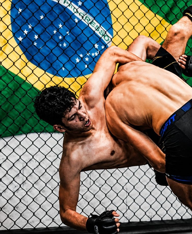 Projection en combat de MMA dans la cage, sous le drapeau du Brésil, au Boxing Center Toulouse États-Unis