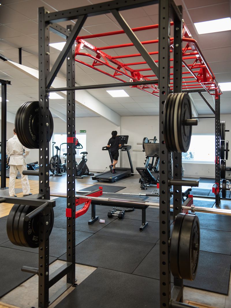 Espace musculation : rack, disques et rig rouge